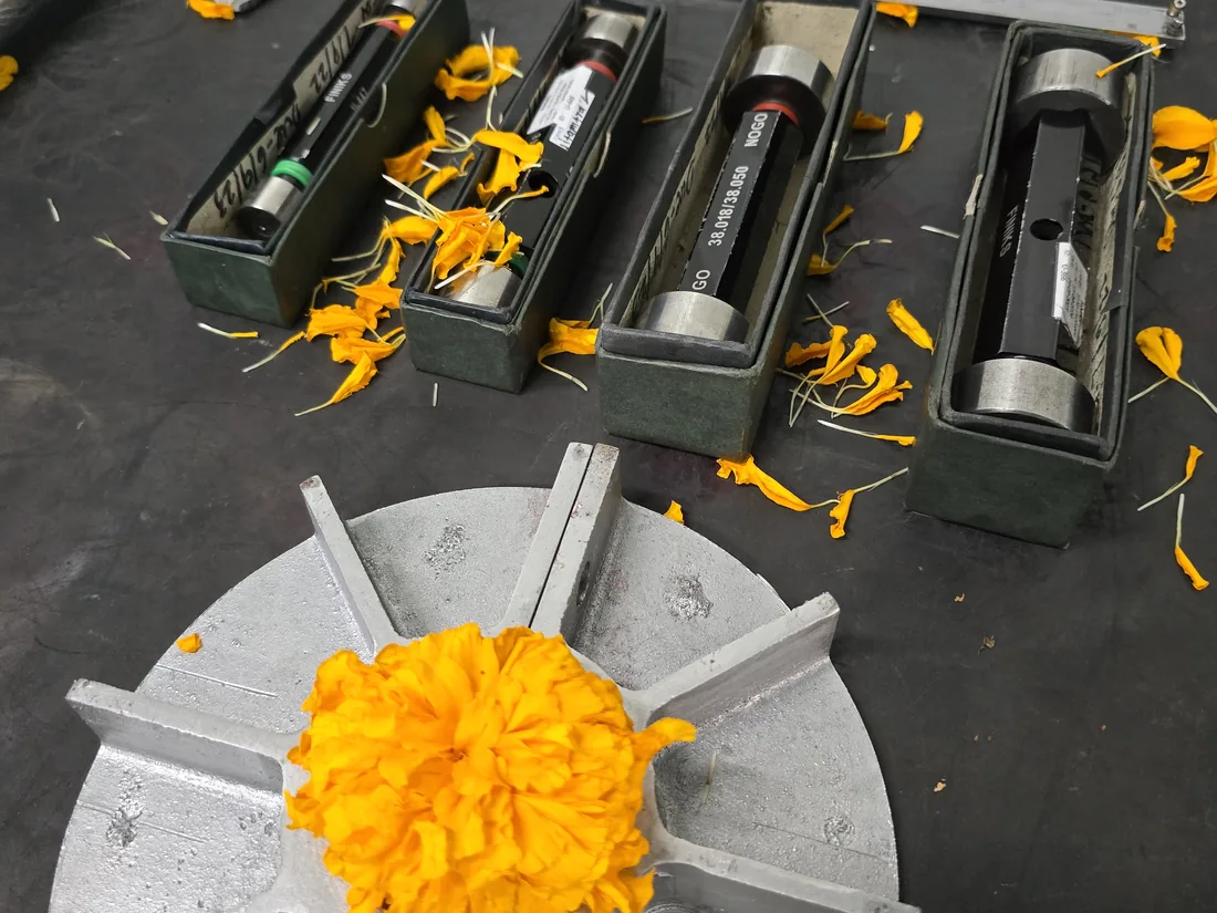 Plug gauges in their cases and a fan wheel marked with marigold flowers for Ayudha Puja
